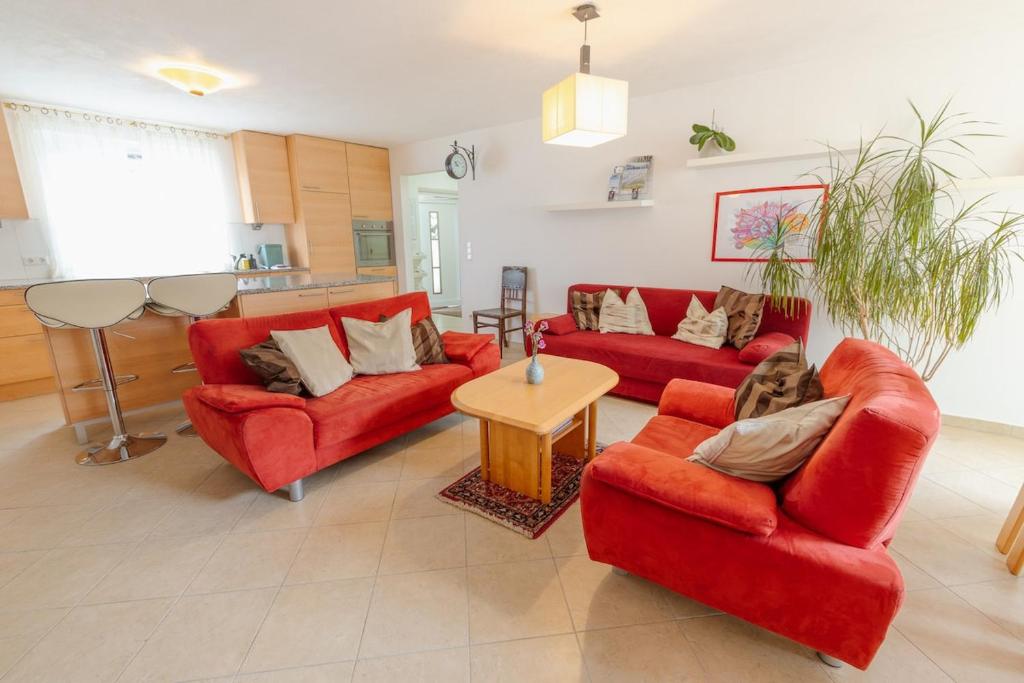 a living room with two red couches and a table at Apartment FreiRaum in Innsbruck