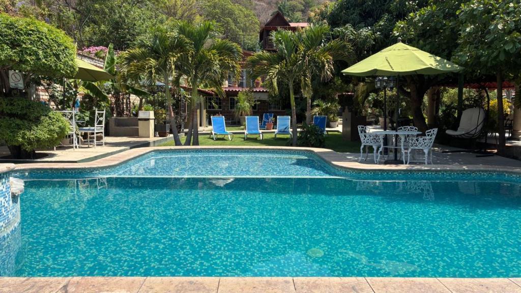 a swimming pool with a table and chairs and an umbrella at Casa de la Abuela in Ajijic