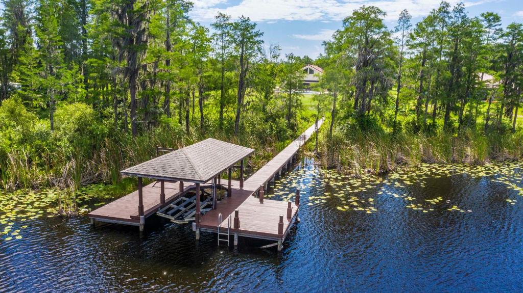 a dock in the middle of a lake with trees at SWISS 105 - Lake Olsen in Clermont