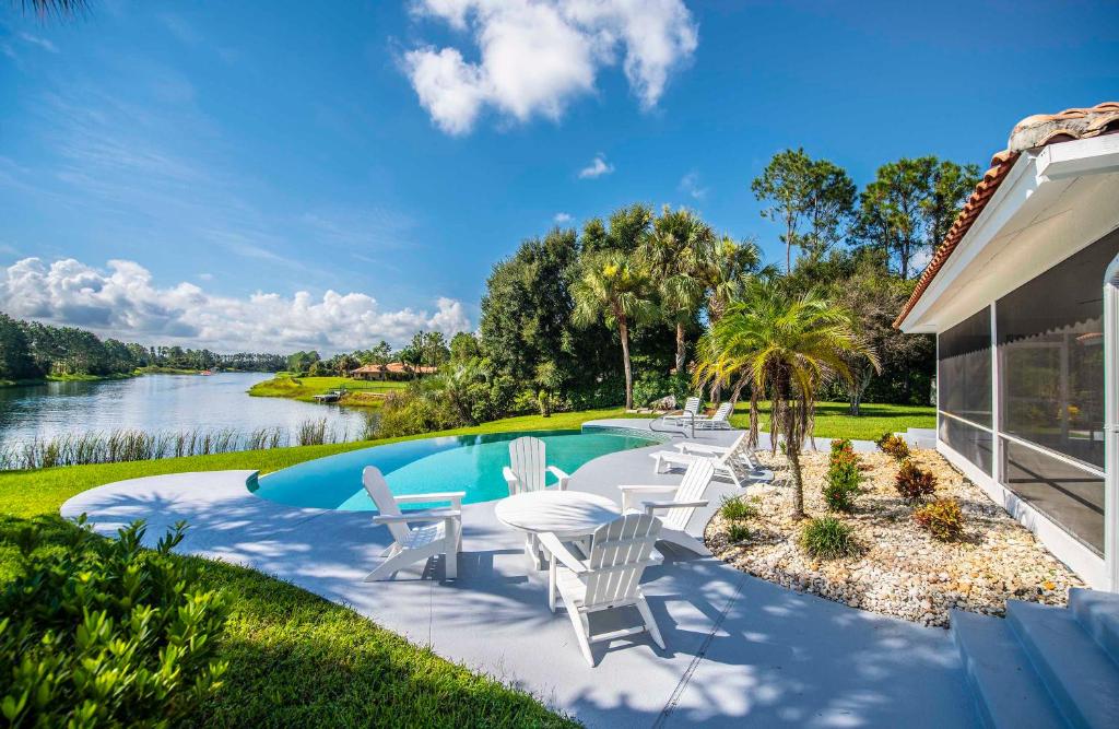 a patio with chairs and a swimming pool next to a house at SWISS 66 - Lake Denise in Clermont