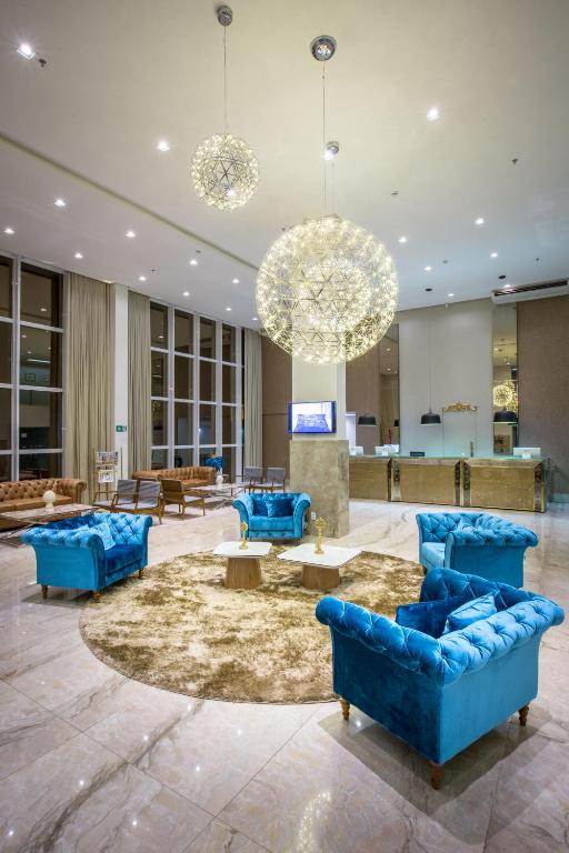 a lobby with blue couches and tables in a building at Céu Palmas Hotel in Palmas