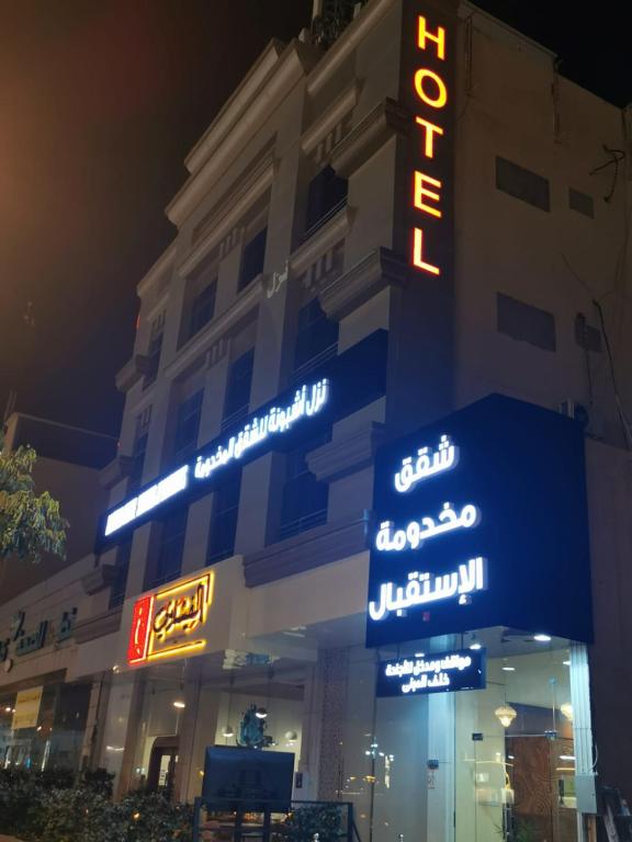 a hotel with neon signs on the side of a building at ashbona suites in Riyadh