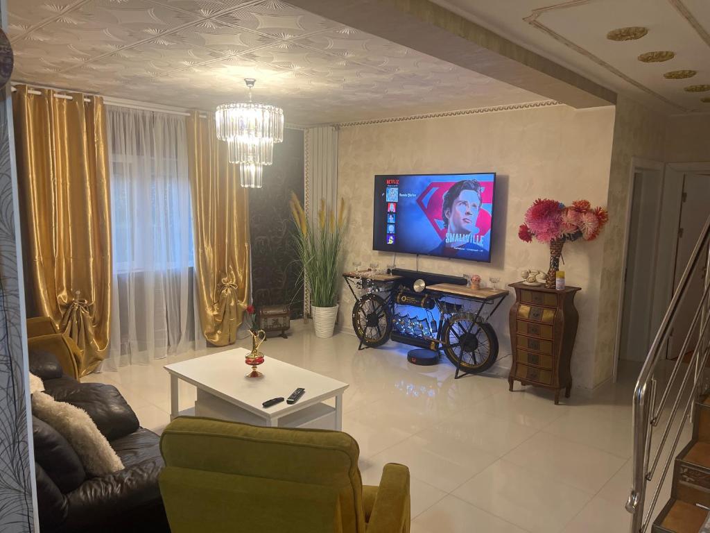 a living room with a couch and a tv at Casa verde in Săcălaz