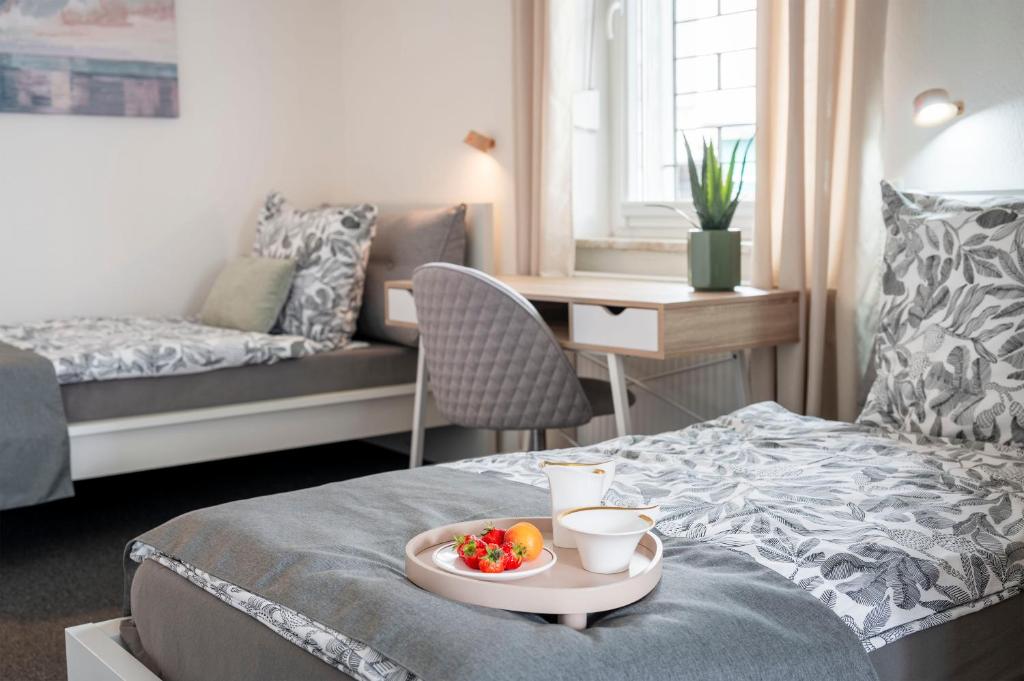 a room with a bed with a tray of fruit on it at Jans 4 Personen Work Apartment mit Küche P WLAN Code NRW Veltins Arena in Herten