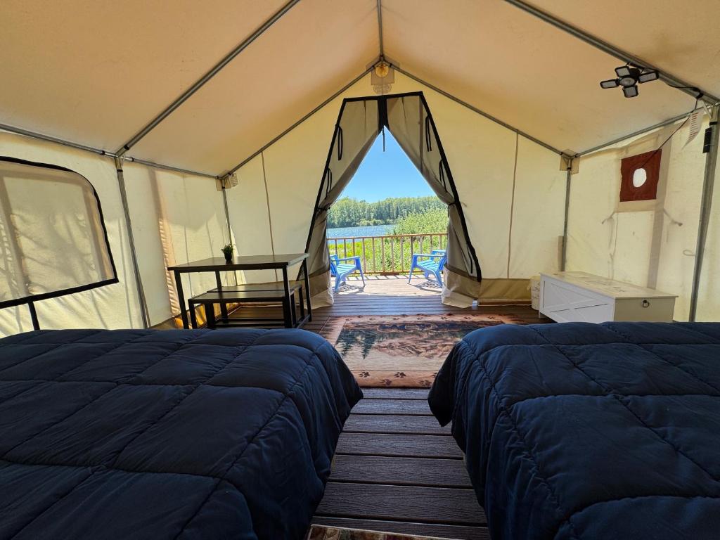 a tent with two beds and a table in it at Emerald - Glamping tent in Klamath