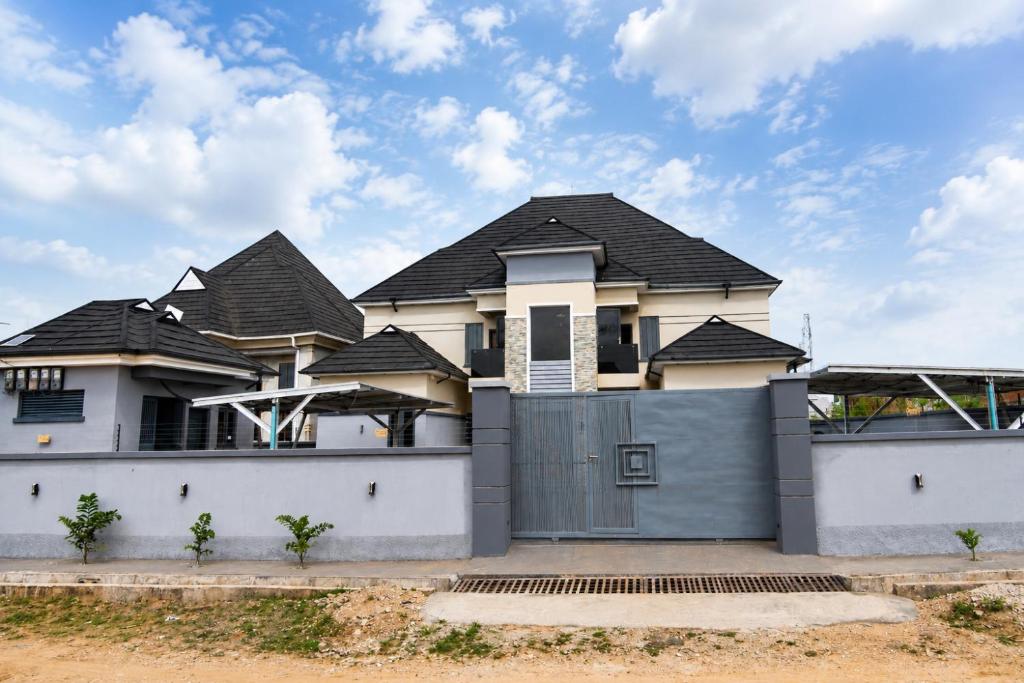 a house with a fence in front of it at The COZY CREST in Akure