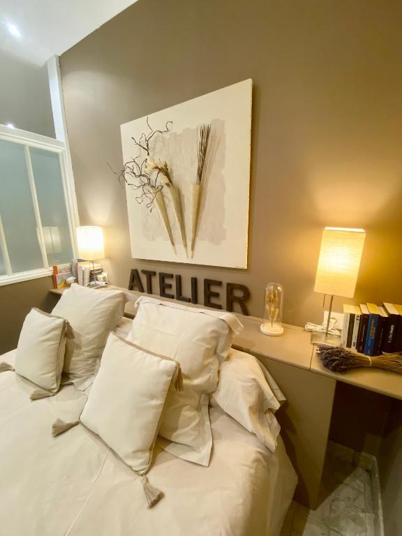 a bedroom with a bed with white pillows at L'Oliveraie de Paul in Aigues-Mortes