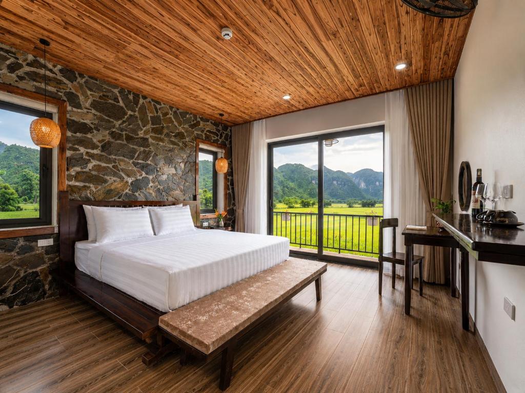a bedroom with a bed and a stone wall at Tam Coc Haven House in Ninh Binh