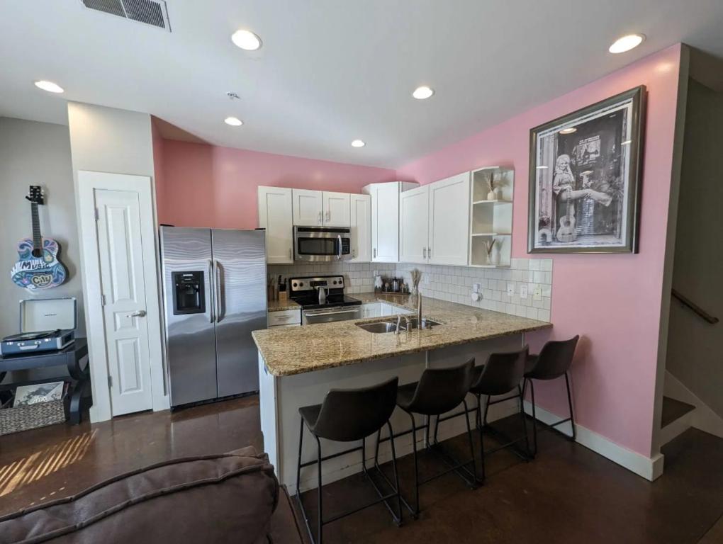 a kitchen with a island with bar stools at 2-Bedroom Condo Unit with Free Parking & 2 King Beds in Nashville