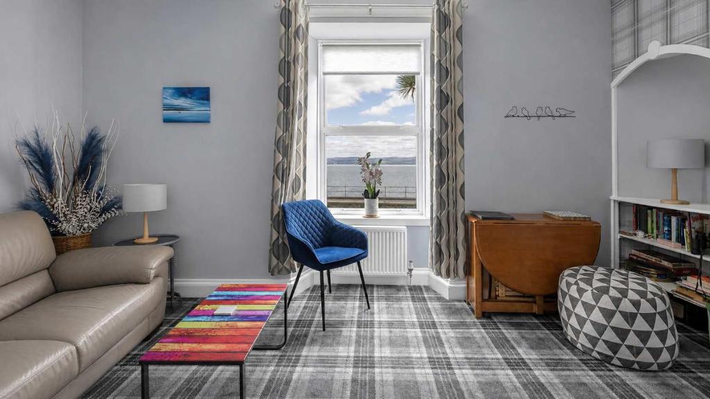 a living room with a couch and a window at Modern Apartment with Garden in Rothesay