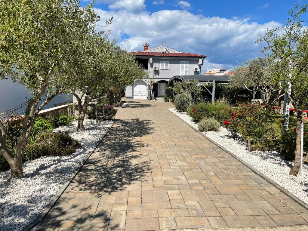 a brick walkway in front of a house with trees at Holiday House Zaton in Zaton