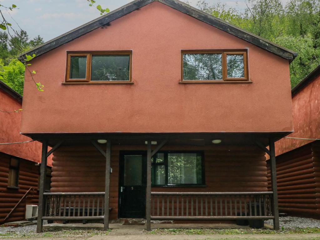 a house with two windows and a porch at Cabin No 5 - Salt and Fern Cabins in Port Talbot
