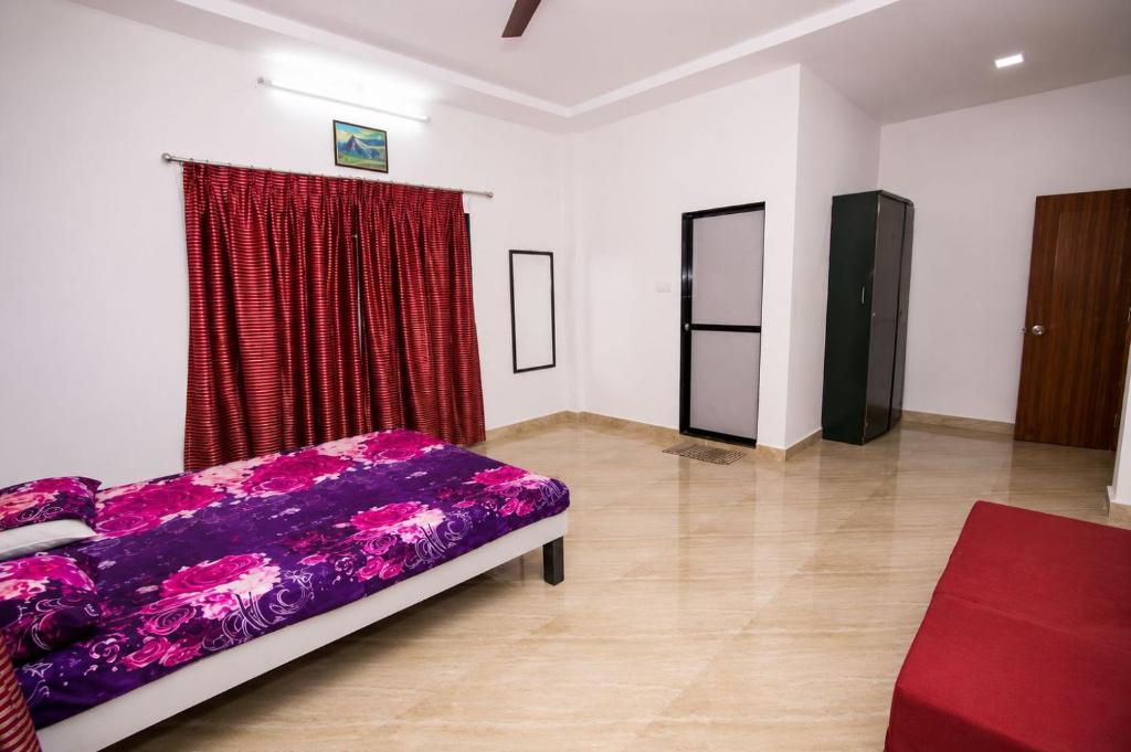a bedroom with a purple bed and a red curtain at Attra Farms in Karjat