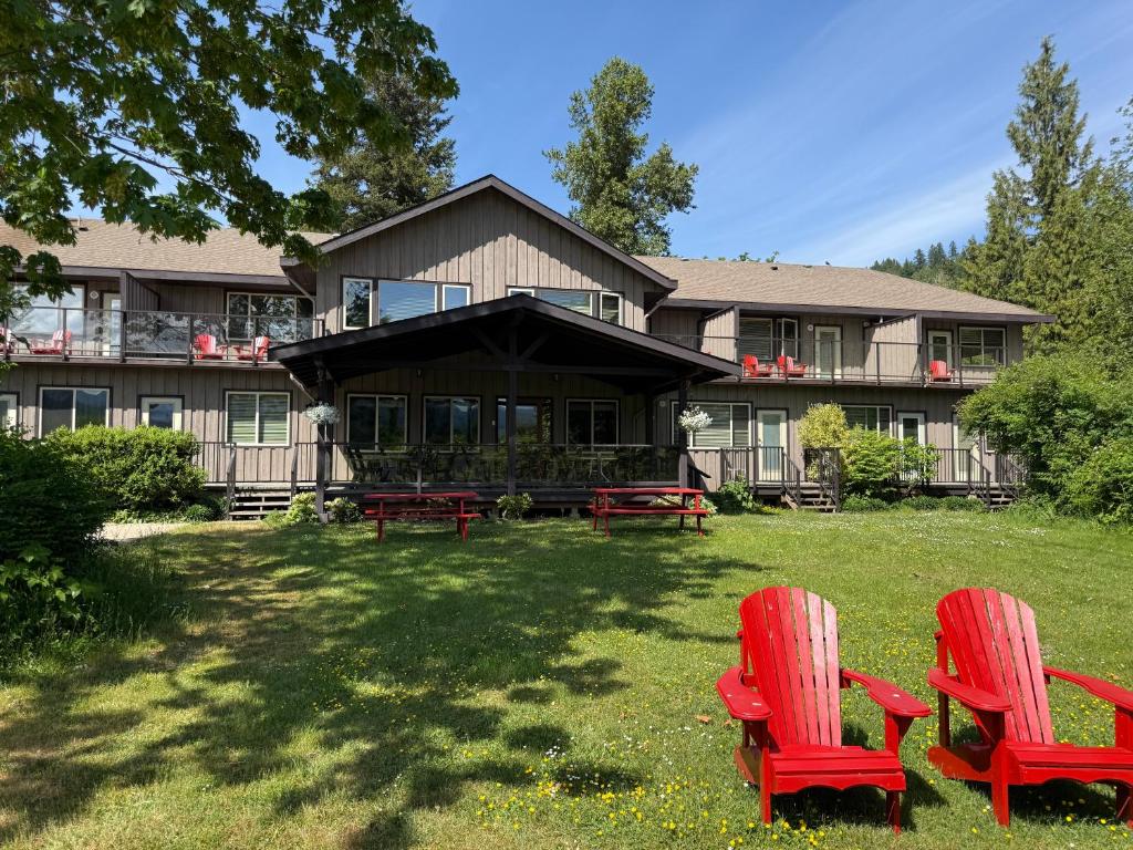 two red chairs sitting in front of a house at Kiwi Cove Lodge in Ladysmith