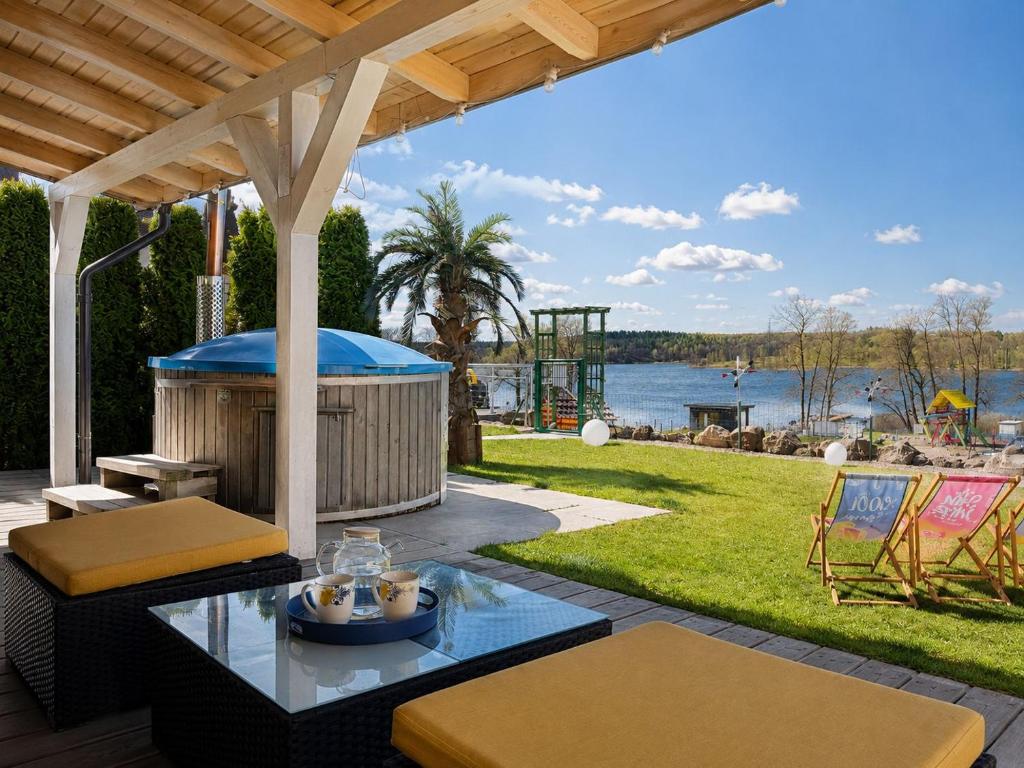 a patio with a gazebo and a view of the water at Apartamenty Liberta in Stare Jabłonki