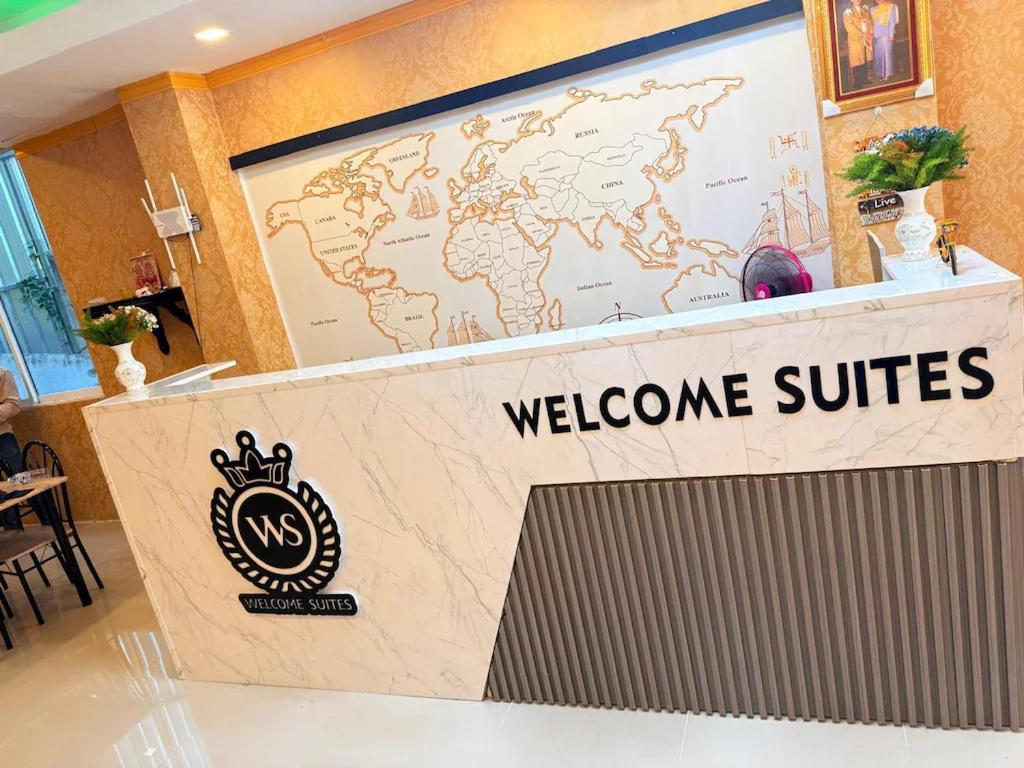 a welcome counter with a welcome sign and a world map at Welcome Suites in Pattaya South