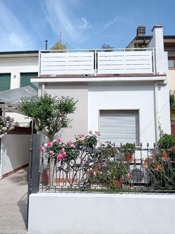 a white house with a balcony with flowers on it at Da' Mi ' Nonni in Viareggio