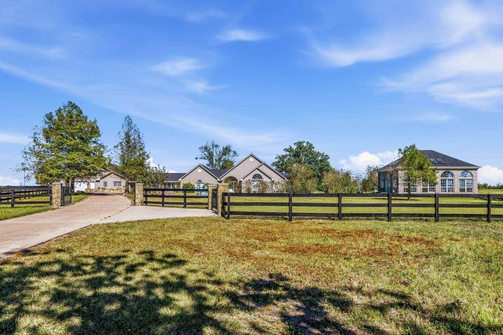 a fence in front of a field with houses at Escape at the SK in Huntsville