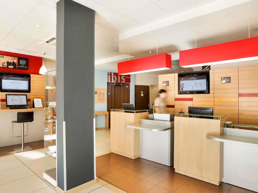 a clinic with a person standing in the lobby at Ibis Brive Centre in Brive-la-Gaillarde