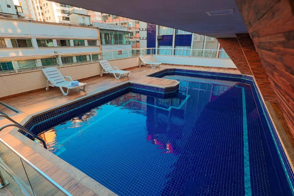 eine Draufsicht auf ein Schwimmbad an einem Gebäude in der Unterkunft Hotel Açores in Balneário Camboriú