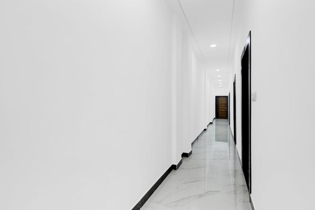 a hallway with white walls and white floors at Super Hotel O Antilia in Gorakhpur