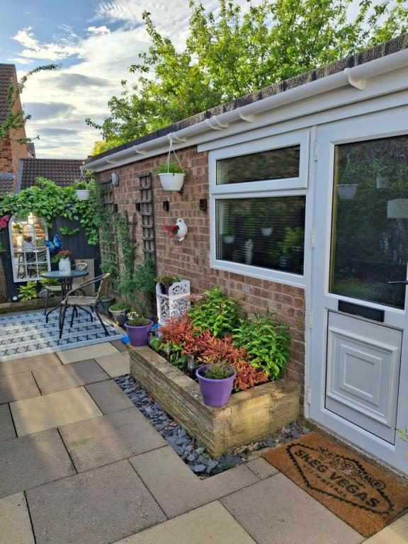 a garden with potted plants next to a building at Nett'Als Lodge Studio Apartment in Derby