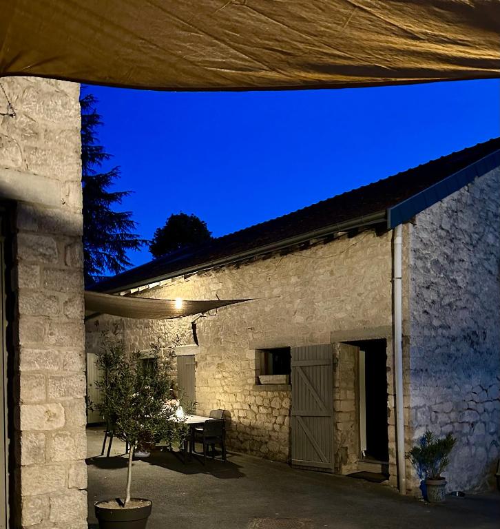 a stone house with a table and a blue sky at Hédoniste 1 in Herpy-lʼArlésienne