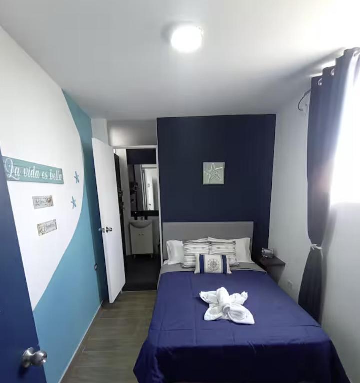 a blue bedroom with a bed with two white flowers on it at Sunset In Malabrigo in Puerto Chicama