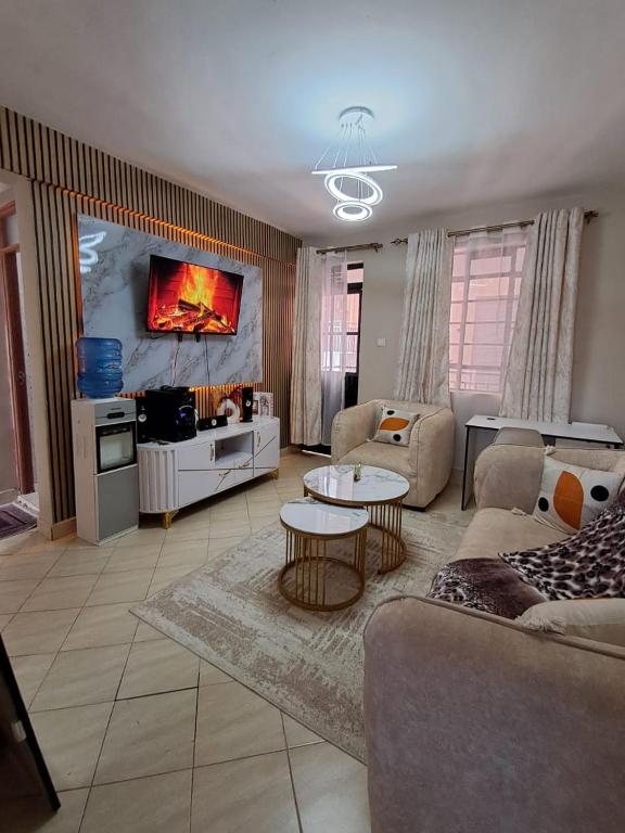 a living room with a couch and a table at Executive 1bedroom Furnished and BnB apartment with GYM,Swimming pool,Cityview - Kitisuru ,Nairobi in Nairobi