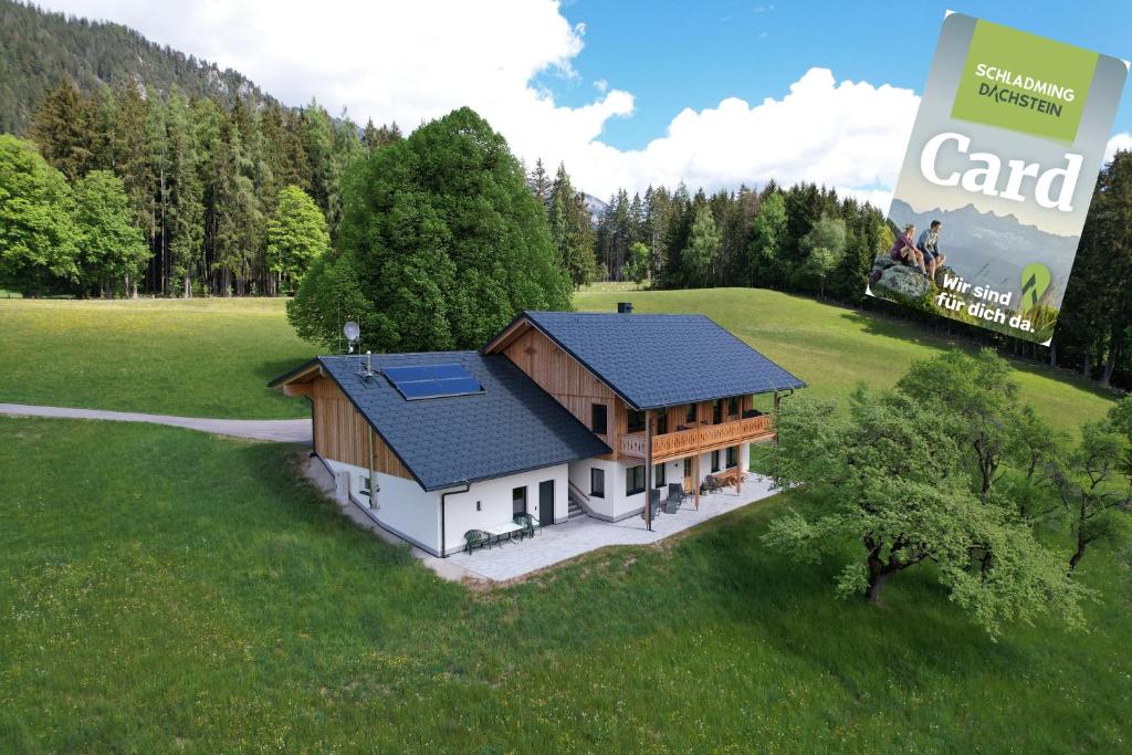 ein Haus mit Solardach auf einem grünen Feld in der Unterkunft Naturchalet Forster in Haus im Ennstal