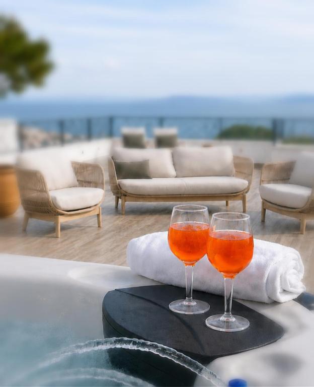 two wine glasses sitting on a tray next to a tub at Mare Vista Rooftop Penthouse Sea View & Private Jacuzzi in Trogir