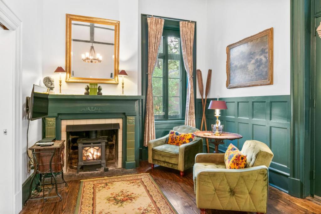 a living room with a fireplace and green walls at Spacious Studio on Historic Inn Property in Asheville