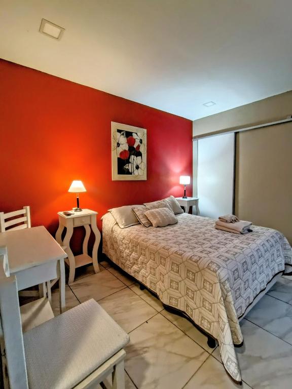 a bedroom with a bed and a red wall at Hotel Alhambra in General Alvear