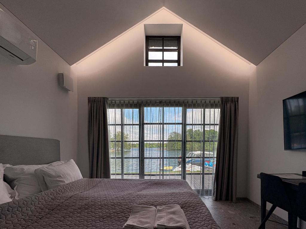 a bedroom with a bed and a large window at Lakeview Modern Karaim Cottage Trakai in Trakai