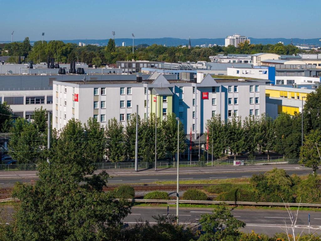 a group of buildings in a city with a parking lot at ibis Hotel Frankfurt Messe West in Frankfurt