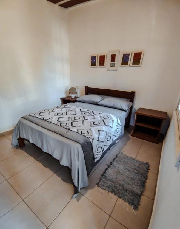 a bedroom with a large bed and a rug at Chalé Refúgio Casarão in Passa Quatro