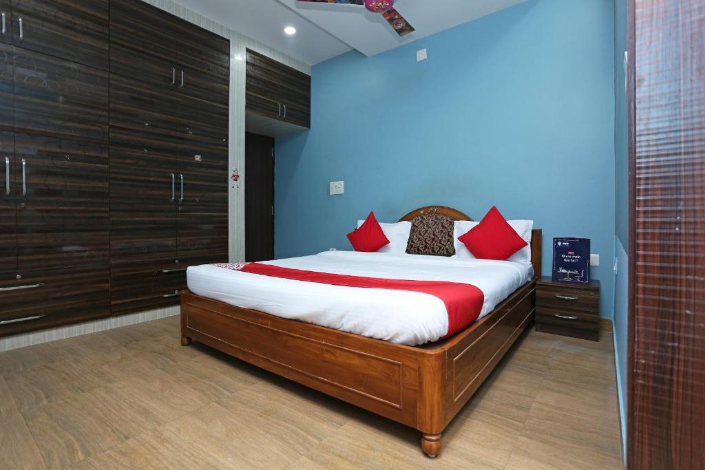 a bedroom with a large bed with red pillows at Hotel O Kalinga Regency in Khandagiri