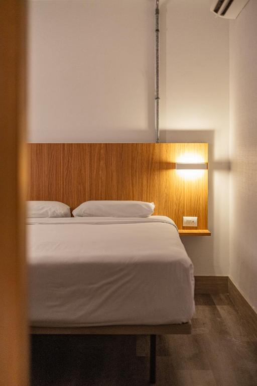 a bedroom with a bed and a light on the wall at Moov Hotel São Paulo in São Paulo