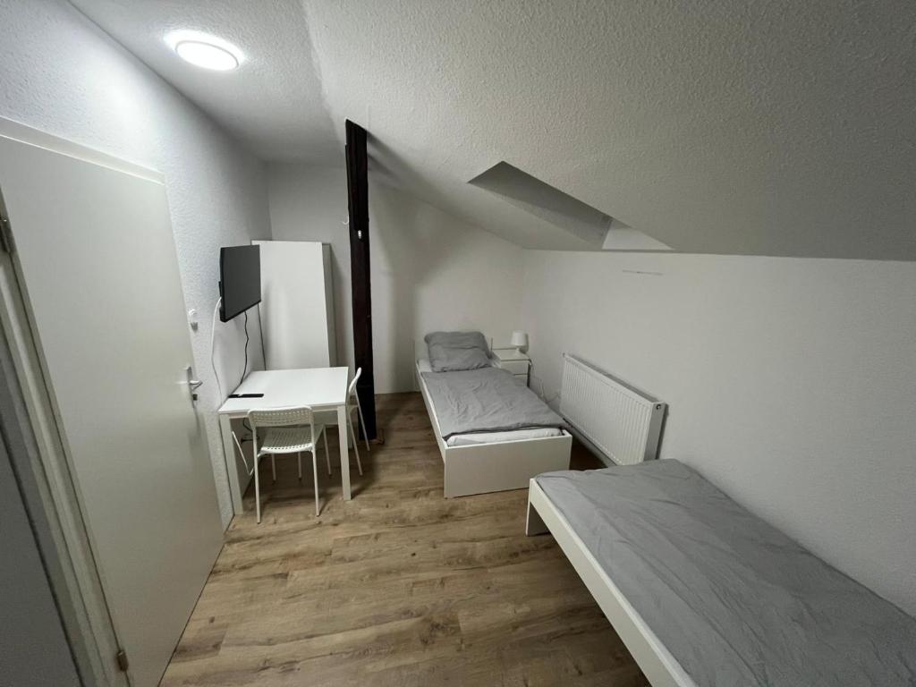 a room with a bed and a table and a desk at Gemütliches kleines Zimmer in Jerrishoe