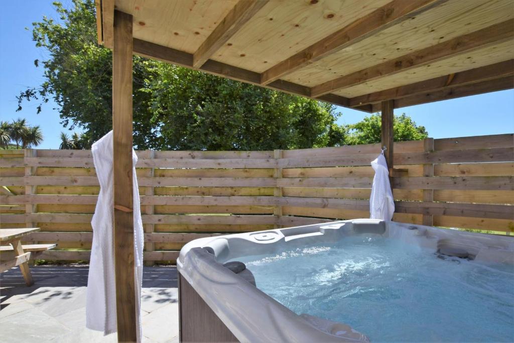 a hot tub under a wooden pergola at 4 Bed in Newquay oc-56747 in Cubert