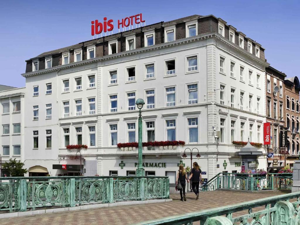 two people walking on a bridge in front of a building at ibis Charleroi Centre Gare in Charleroi