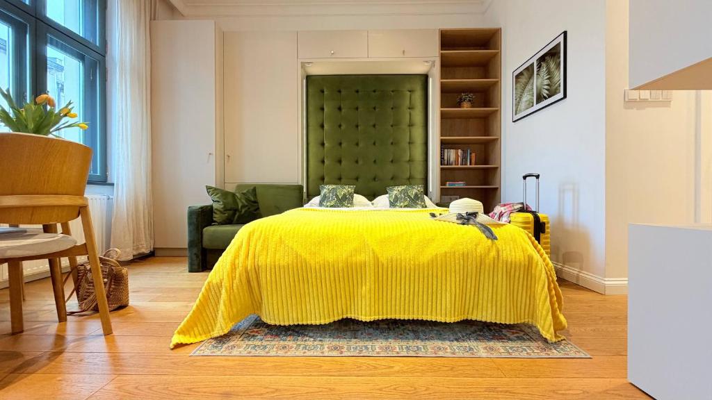 a bedroom with a yellow bed with a green headboard at Ruzop Apartament - Modern studio in center, self check-in, WiFi in Poznań