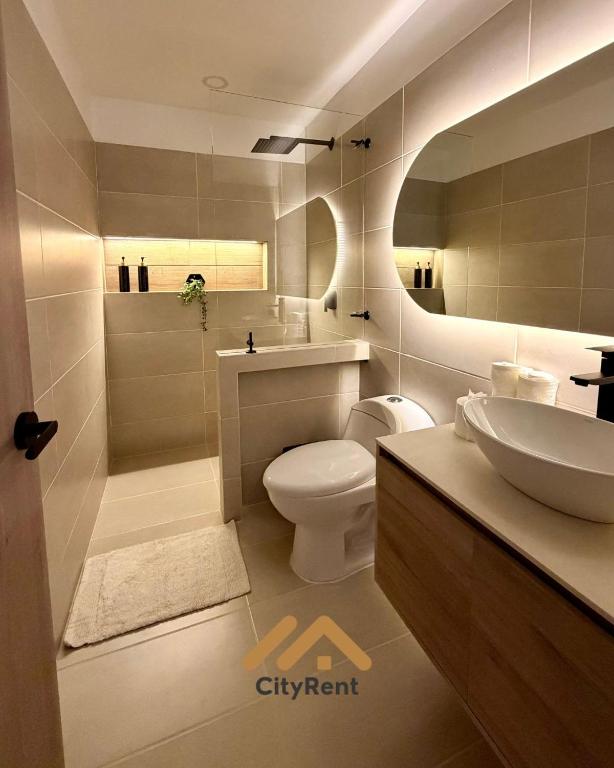 a bathroom with a toilet and a sink and a mirror at Casa Martina premiun in Buga
