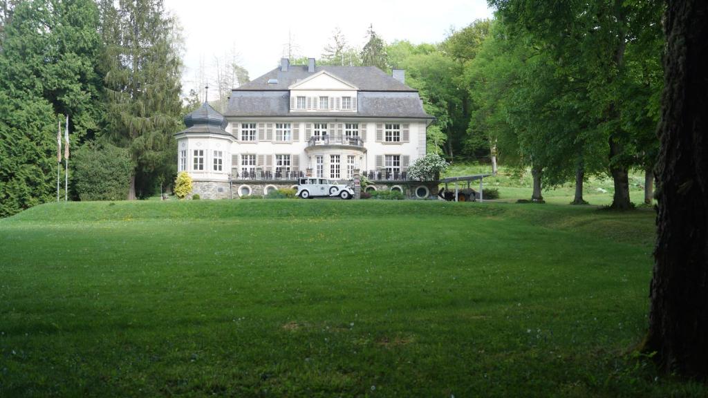 a large white house with a truck in front of it at Landsitz Kammerburg - Villa in Lorch am Rhein
