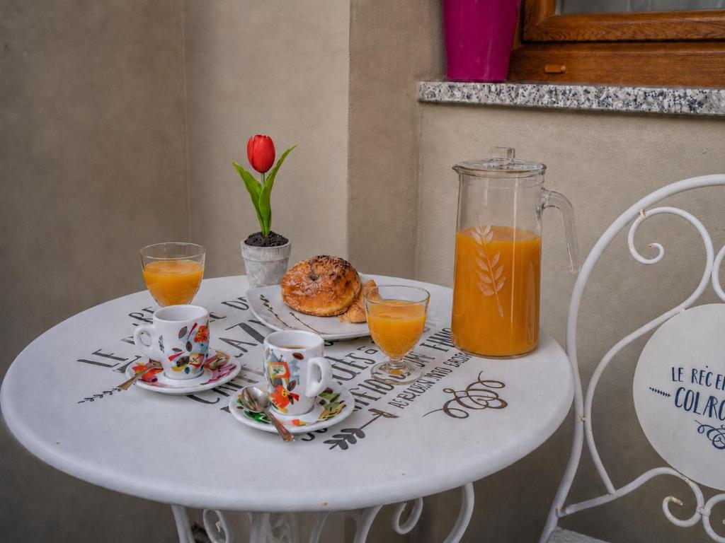 a white table with a plate of food and orange juice at L'Aurora Porto Torres in Porto Torres