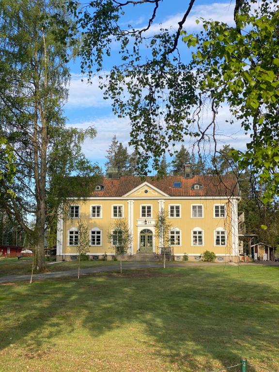 a large yellow house with a large yard at Lappnäs Bed & Breakfast in Sunne