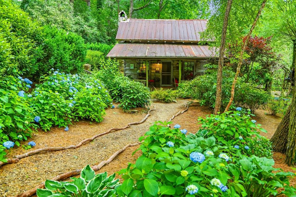 a house in the middle of a garden with flowers at Melrose Cabin in Highlands