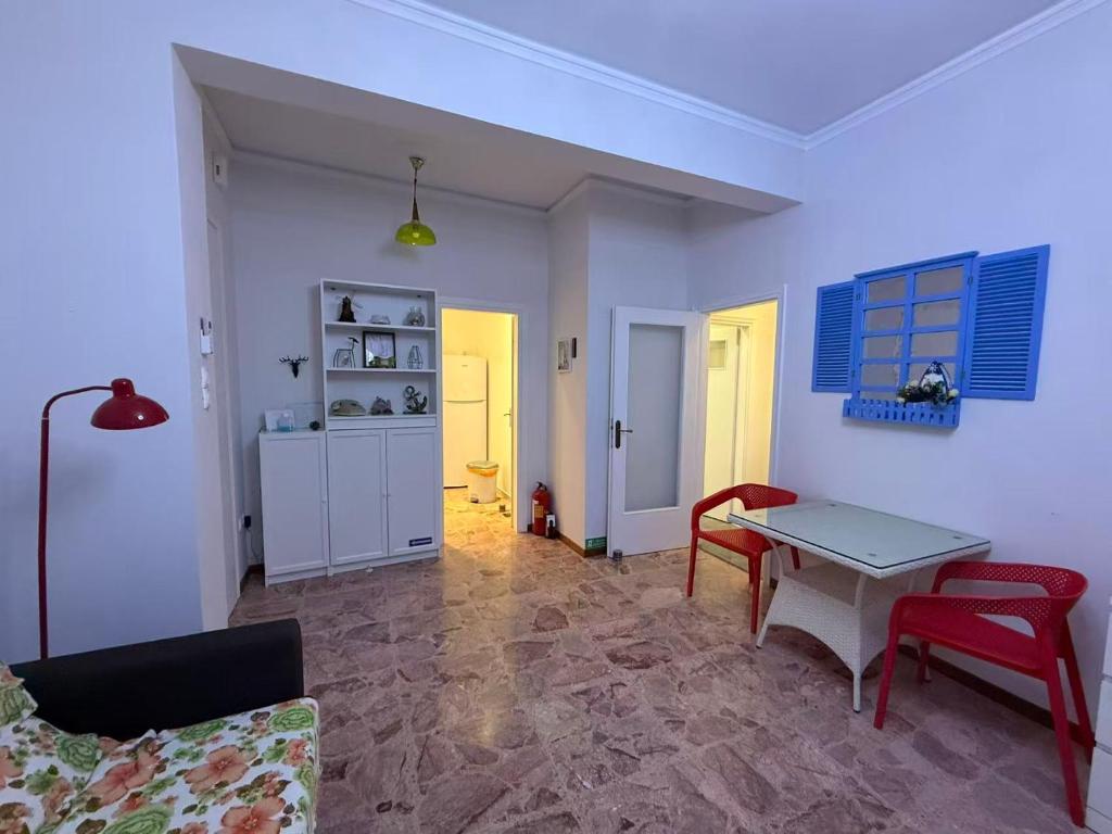 a living room with a table and red chairs at Sail Haven in Vari