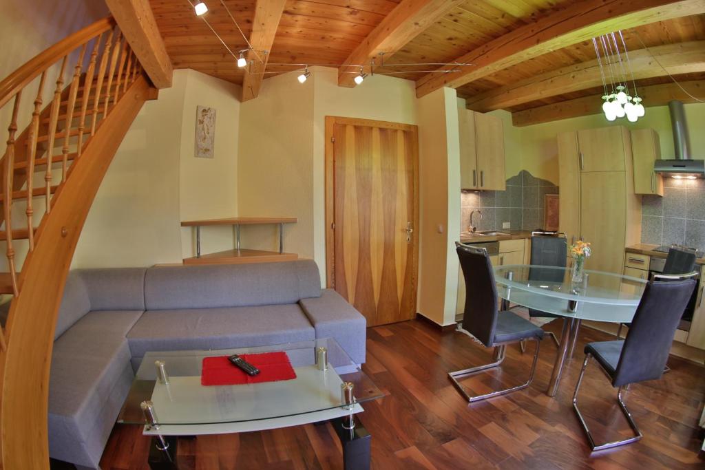 un soggiorno con divano e tavolo di Garten- & Loggia-Appartement HERRENHAUS a Dellach im Drautal