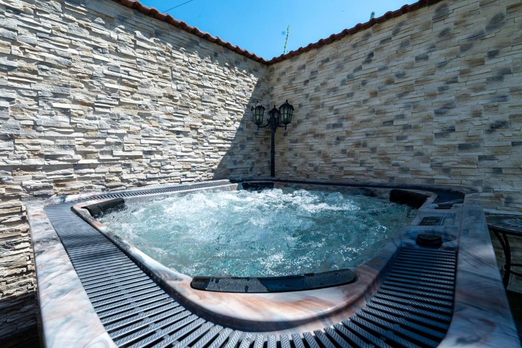 ein Whirlpool in der Ecke einer Backsteinmauer in der Unterkunft Casa Dudu in Moieciu de Jos